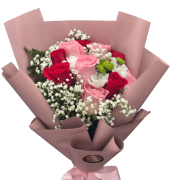 Bouquet of pink and red roses with white filler flowers in pink wrap