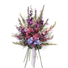 Tall bouquet of purple and pink flowers with a lavender ribbon