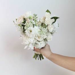 White and cream bouquet of roses and mixed blooms held in hand