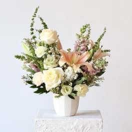 Mixed bouquet of roses and lilies in a white vase
