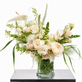 Cream and white floral arrangement in a clear glass vase