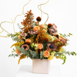 Peach roses and mixed autumn flowers in a square vase