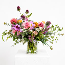 Mixed pink and purple flowers in a clear glass vase