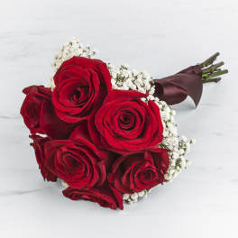 Bouquet of red roses with white baby's breath wrapped in burgundy ribbon