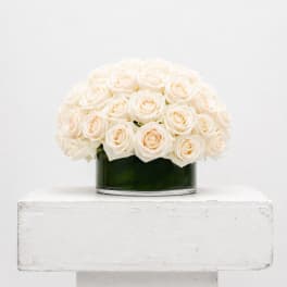 White roses arranged in a low glass vase