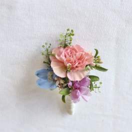 Small pink and blue floral boutonniere with green accents