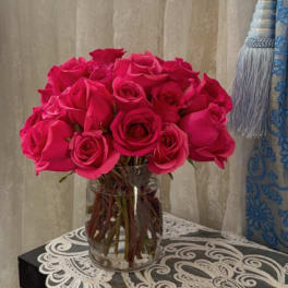 Hot pink roses arranged in a clear glass vase