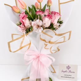 Pink tulips and roses in white wrap with a pink ribbon