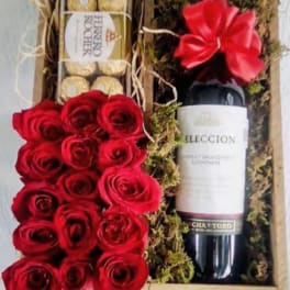 Gift box with red roses, chocolates, and a wine bottle