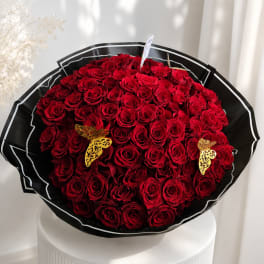 Large bouquet of red roses wrapped in black paper