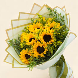Bouquet of yellow sunflowers wrapped in pale green paper