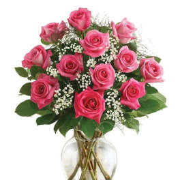 Pink roses arranged in a clear glass vase with white filler flowers