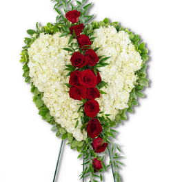 Heart-shaped white floral spray with red roses on a stand