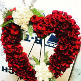 Heart-shaped wreath of red and white roses on a stand