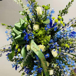 Large blue and white floral standing spray with green ribbon