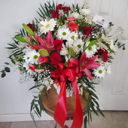 Large bouquet of red, white, and pink flowers with a red ribbon