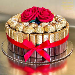 Chocolate gift box topped with two red roses and a ribbon