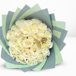 Bouquet of cream roses wrapped in layered blue and green paper