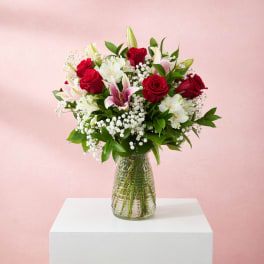 Red roses and white lilies in a clear glass vase