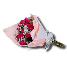 Bouquet of hot pink roses and white filler flowers wrapped in pink and white paper