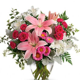 Pink lilies and roses in a clear glass vase