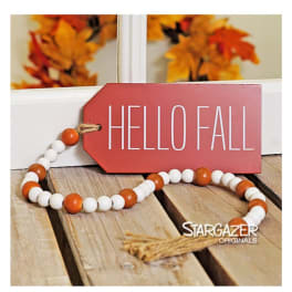 Fall-themed tag with beaded garland on a wooden surface