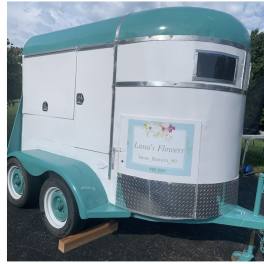 Teal and white flower trailer with a Lana's Flowers sign