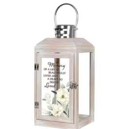 Decorative memorial lantern with white flowers and a printed tribute message