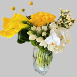 Yellow and white floral arrangement in a clear glass vase