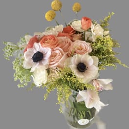Bouquet of peach and white flowers in a clear glass vase