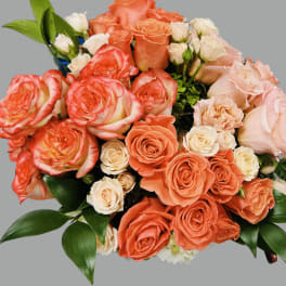 Bouquet of coral and blush roses with white spray roses