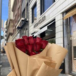Bouquet of red roses wrapped in brown paper