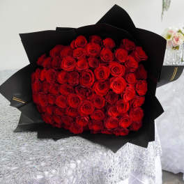 Bouquet of red roses wrapped in black paper
