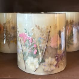Decorative candle in a clear glass jar with pressed flowers