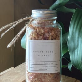 Glass jar of pink bath salt with a twine tie and label