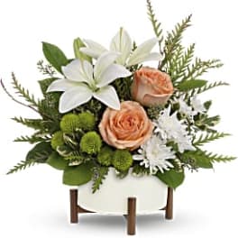 White lilies and peach roses in a white container
