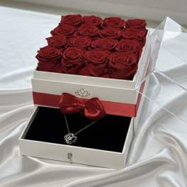 Box of red roses with a necklace in a drawer below