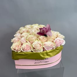Box of pale pink roses with one purple lily