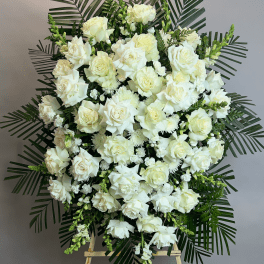 Large white rose funeral spray on an easel