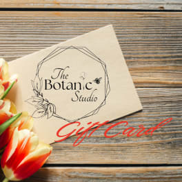 Tulips beside a floral gift card on a wood surface