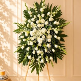 Large white floral standing spray with roses and lilies on an easel