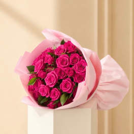 Bouquet of bright pink roses wrapped in pale pink paper