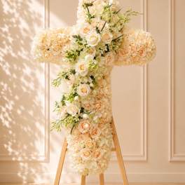 Cream floral cross on a wooden stand