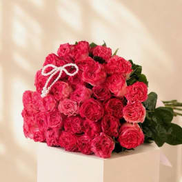 Bouquet of bright pink roses with a white beaded bow