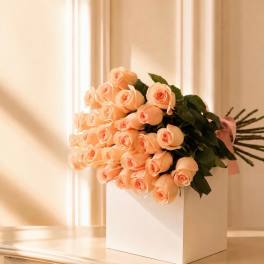 Bouquet of peach roses in a white box with a pink ribbon