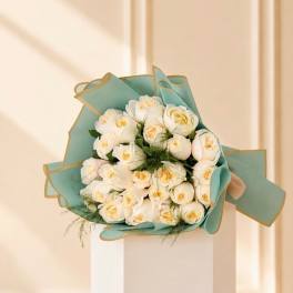 Bouquet of white roses wrapped in teal paper