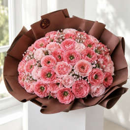 Bouquet of pink ranunculus wrapped in brown paper