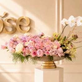 Pastel pink and white floral arrangement in a low pedestal bowl