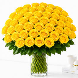 Large bouquet of yellow roses in a clear glass vase