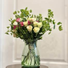 Bouquet of pink and cream roses in a clear glass vase